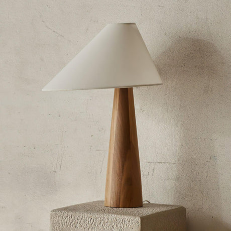 Wood cone lamp on a stone plinth against a plaster wall