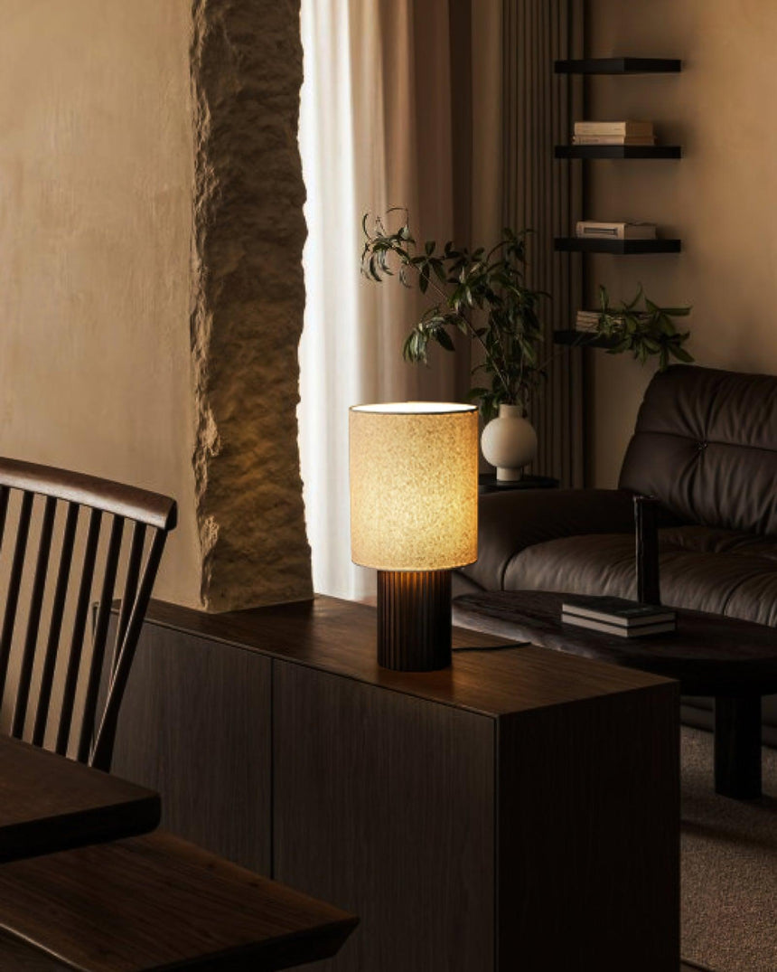 Entryway table lamp unlit on a dark sideboard in a warm room