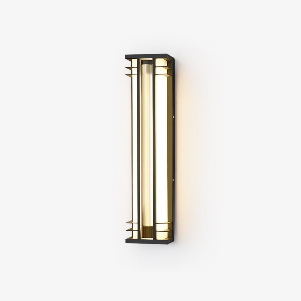 Black box outdoor wall light with gold tone trim and a ribbed acrylic panel, lit warm