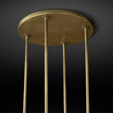 The brass ceiling plate with the four stems that carry the ring below it