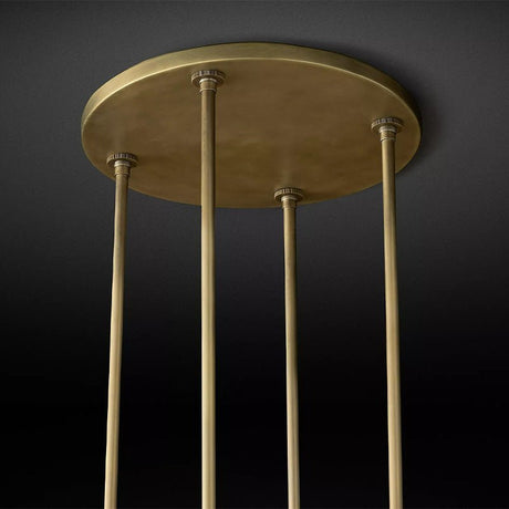 The brass ceiling plate with the four stems that carry the ring below it