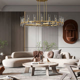 The brass ring lit above a curved sofa, a round wooden table and wall art