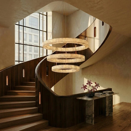 Three rings falling beside a curved staircase in an open stairwell