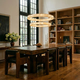 Three lit rings above a long timber dining table and chairs