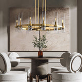 The brass ring above a round dining table with stools and a potted olive tree