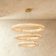 Three stacked alabaster rings lit on thin cables under a brass plate