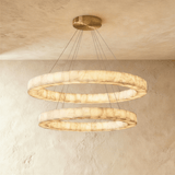 Two lit alabaster rings hung one above the other from a brass plate