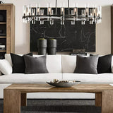 The black ring lit above a white sofa with cushions and a low wooden table