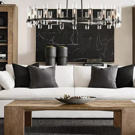 The black ring lit above a white sofa with cushions and a low wooden table