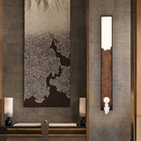 Bar upright on a stone wall beside a hanging artwork and a low bed