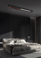 Bar mounted flat above a bed with rumpled bedding in a dark bedroom