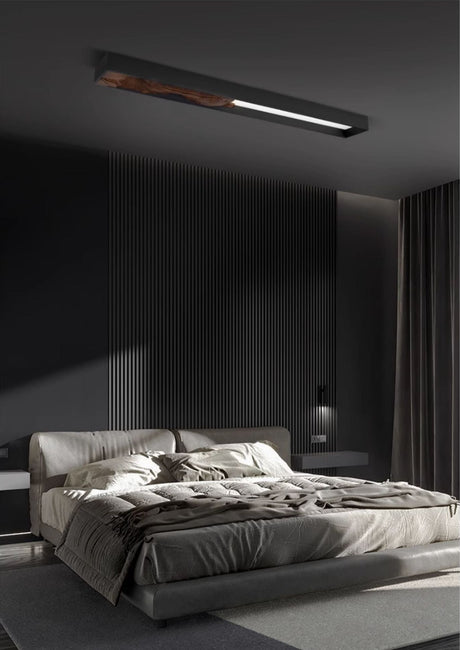 Bar mounted flat above a bed with rumpled bedding in a dark bedroom