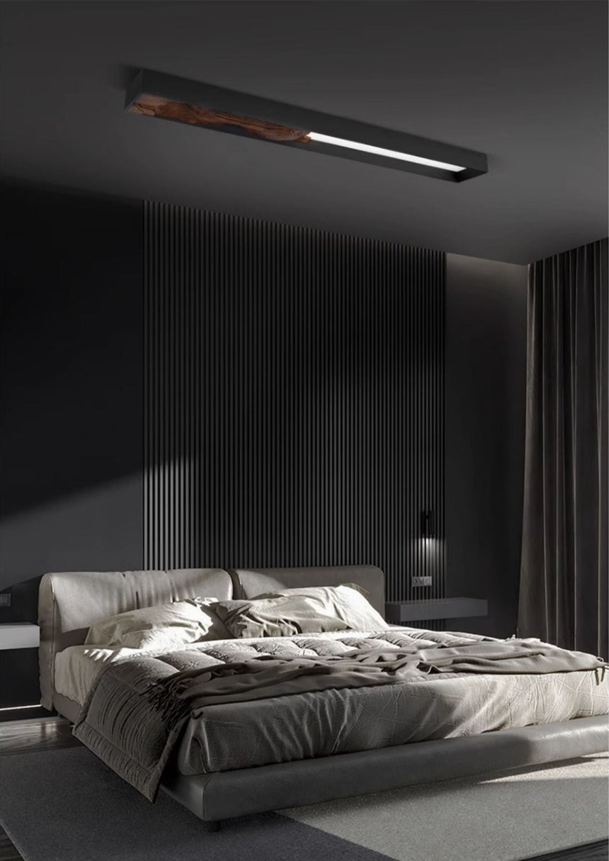 Bar mounted flat above a bed with rumpled bedding in a dark bedroom