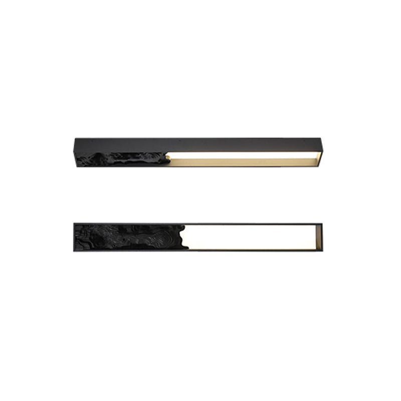 Black version of the carved bar shown upright and lying flat, lit warm