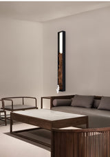 Bar upright on a pale wall beside a low wood table and floor seating