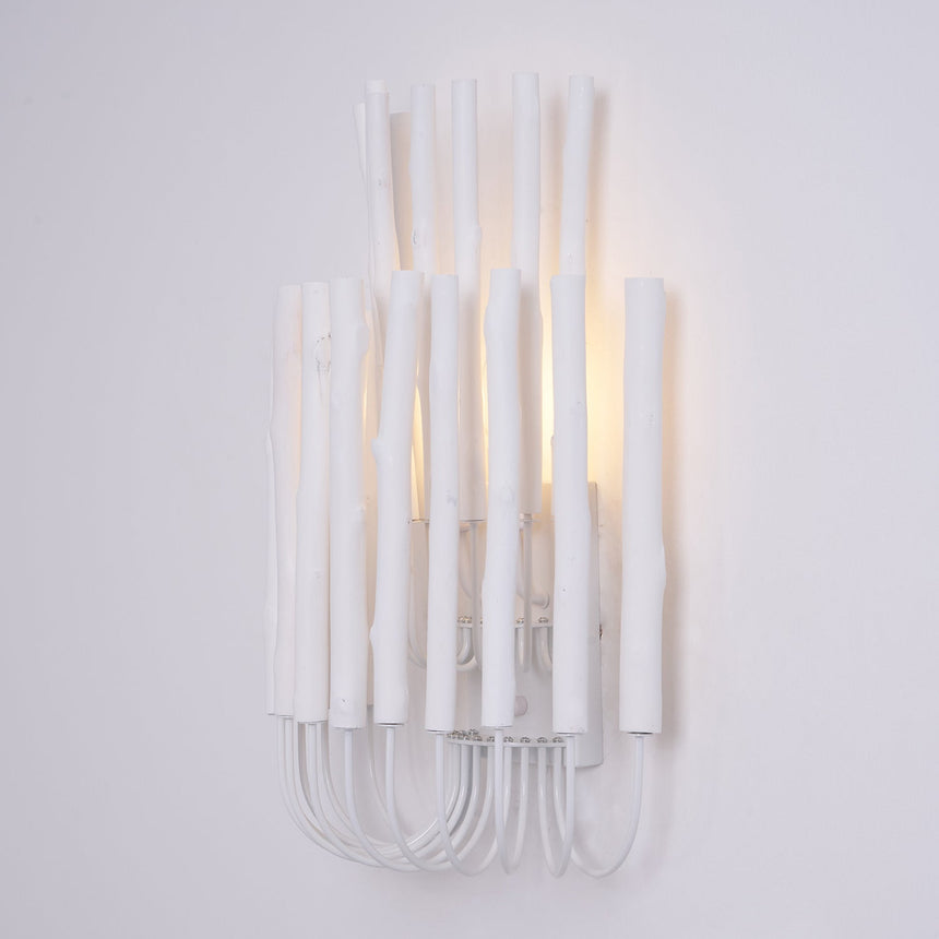 White wood rods of uneven height standing on looped wire, seen straight on