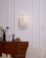 Rod sconce lit above a mid century sideboard beside an upholstered chair