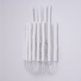Cluster of white wood rods unlit, the looped frame visible underneath
