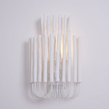 Warm light glowing between white wood rods on a plain pale wall