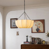 Gathered fabric shade lit above a console with framed art