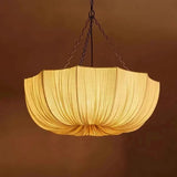 Gathered fabric shade glowing against a dark brown background