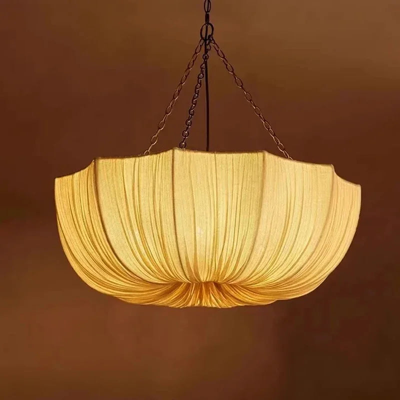 Gathered fabric shade glowing against a dark brown background