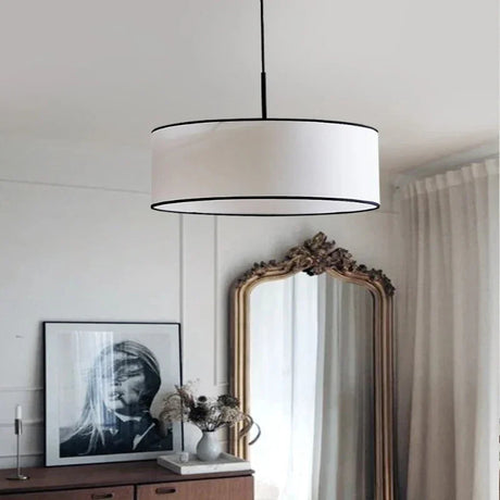 Fabric drum pendant light in white hand knitted cloth beside a tall mirror