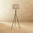 The crossed black tripod carrying a gray fabric drum shade at the top