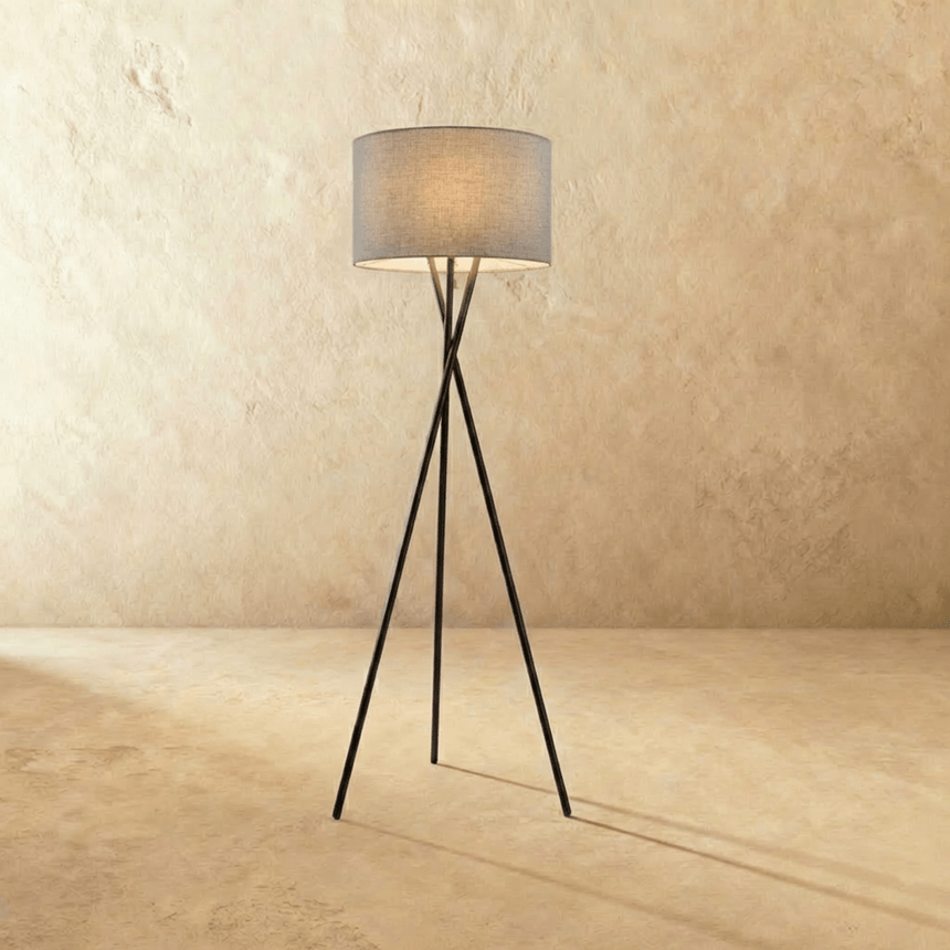The crossed black tripod carrying a gray fabric drum shade at the top