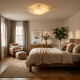 Square silk ceiling light above a bed with a woven rug and an armchair