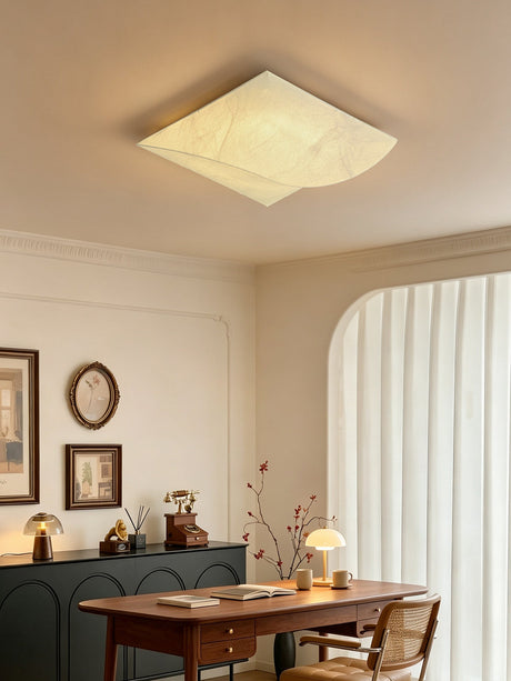 Square silk ceiling light in a room with a curved curtain and framed plates