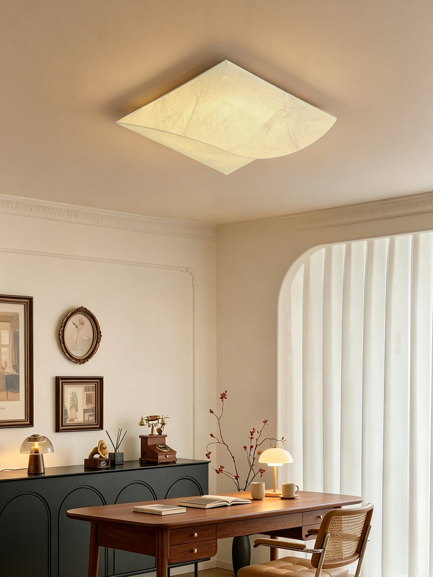 Square silk ceiling light in a room with a curved curtain and framed plates