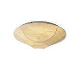 Round silk ceiling light seen at an angle against a plain backdrop