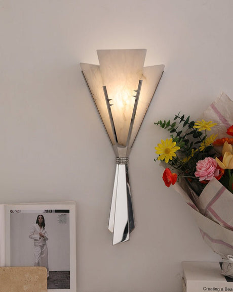The fan sconce lit above a table with a framed photo and a bouquet of flowers