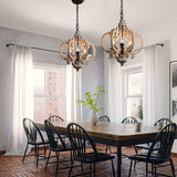 Two of the fittings lit above a dark dining table and spindle chairs