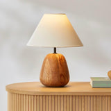 Farmhouse table lamp on a fluted sideboard beside books and fruit
