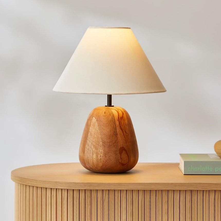 Farmhouse table lamp on a fluted sideboard beside books and fruit