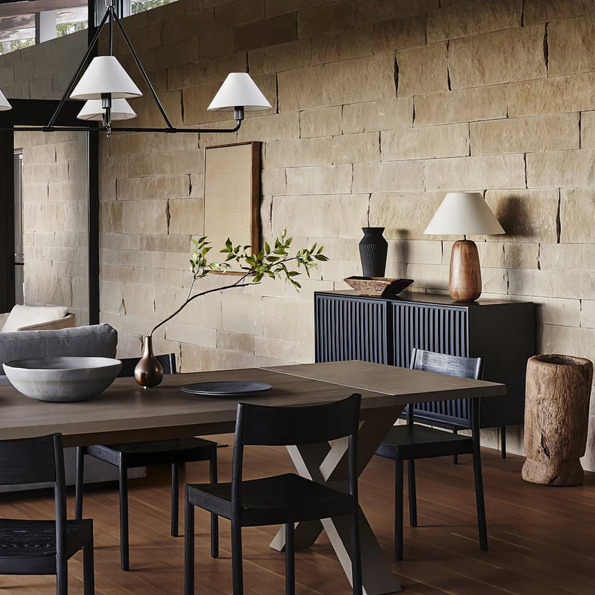 Farmhouse table lamp on a dark sideboard in a dining room with a brick wall