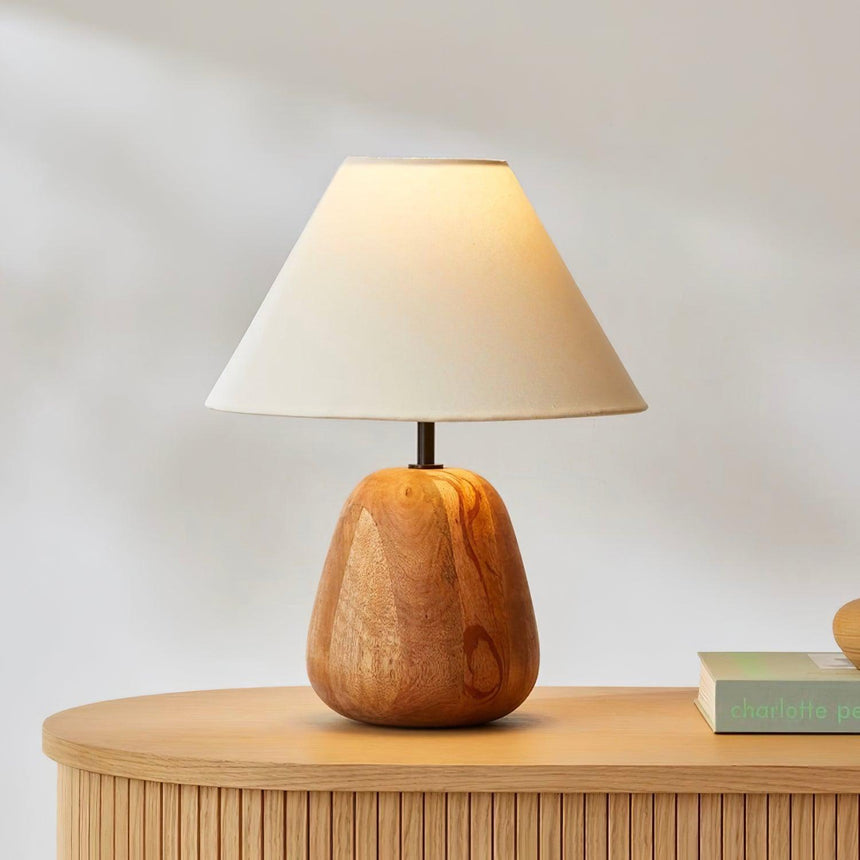 Close view of the turned wood body and the cream coolie shade above it