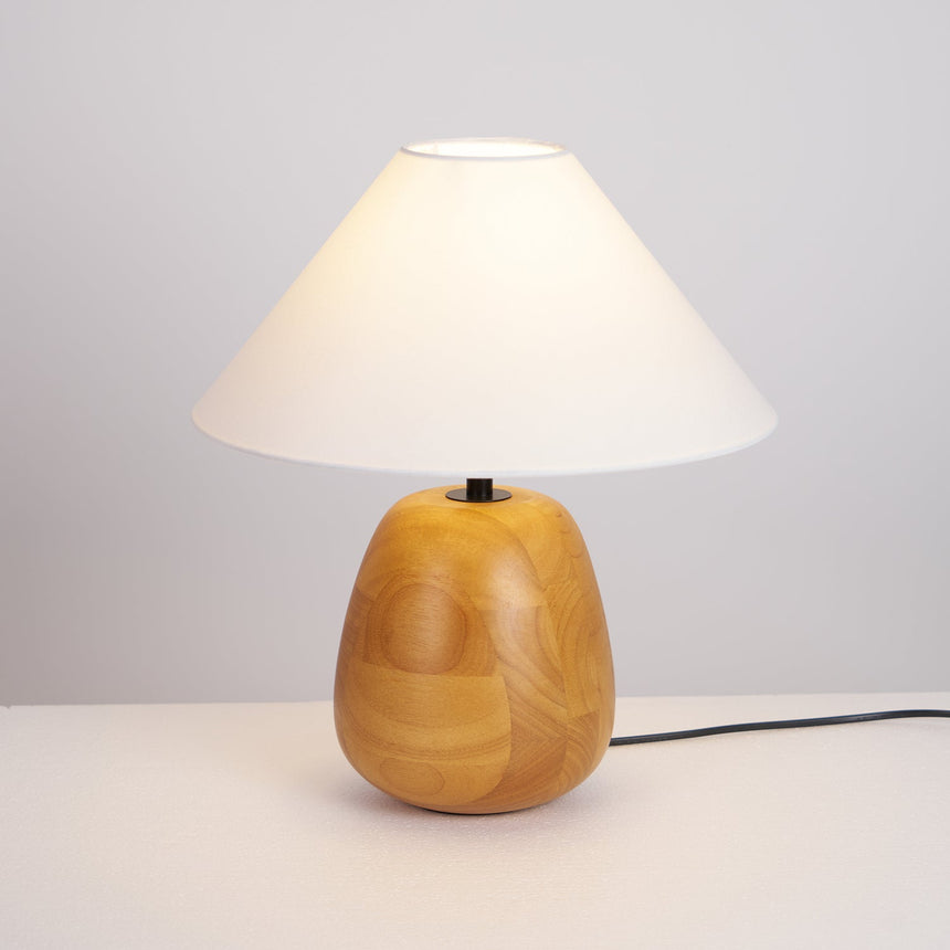Farmhouse table lamp switched on against a plain pale background