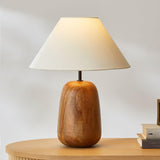 Farmhouse table lamp on a pale round table beside two small books