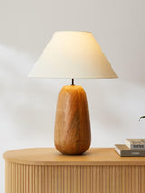 Farmhouse table lamp seen from the front, cream shade over the wood body