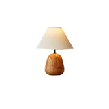 Small farmhouse table lamp seen alone against a plain pale background