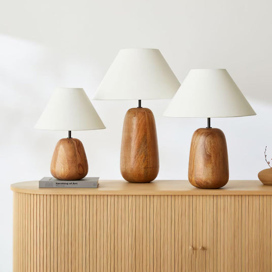 Three sizes of the farmhouse table lamp standing in a row on a sideboard