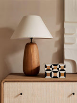 Farmhouse table lamp lit on a drawer unit beside a patterned tile