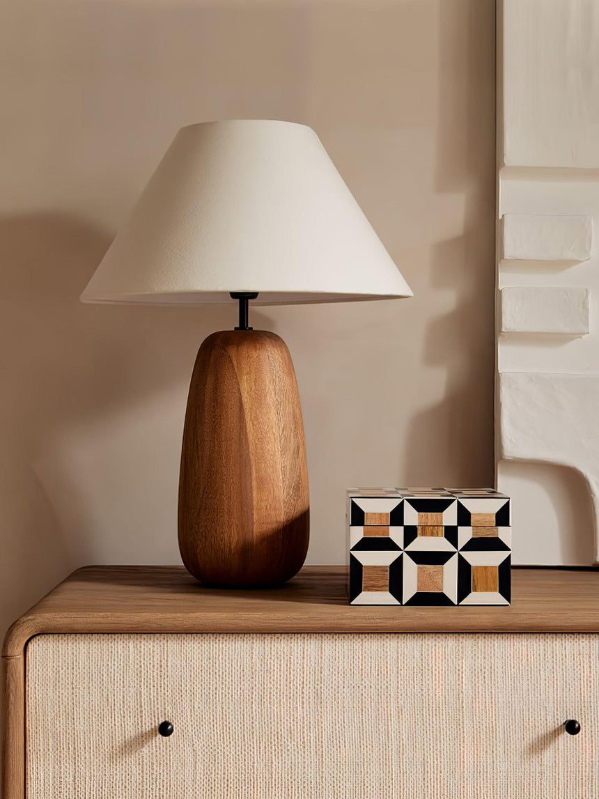 Farmhouse table lamp lit on a drawer unit beside a patterned tile