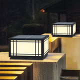 Two lit cube lanterns on pillars beside pale steps at nightfall