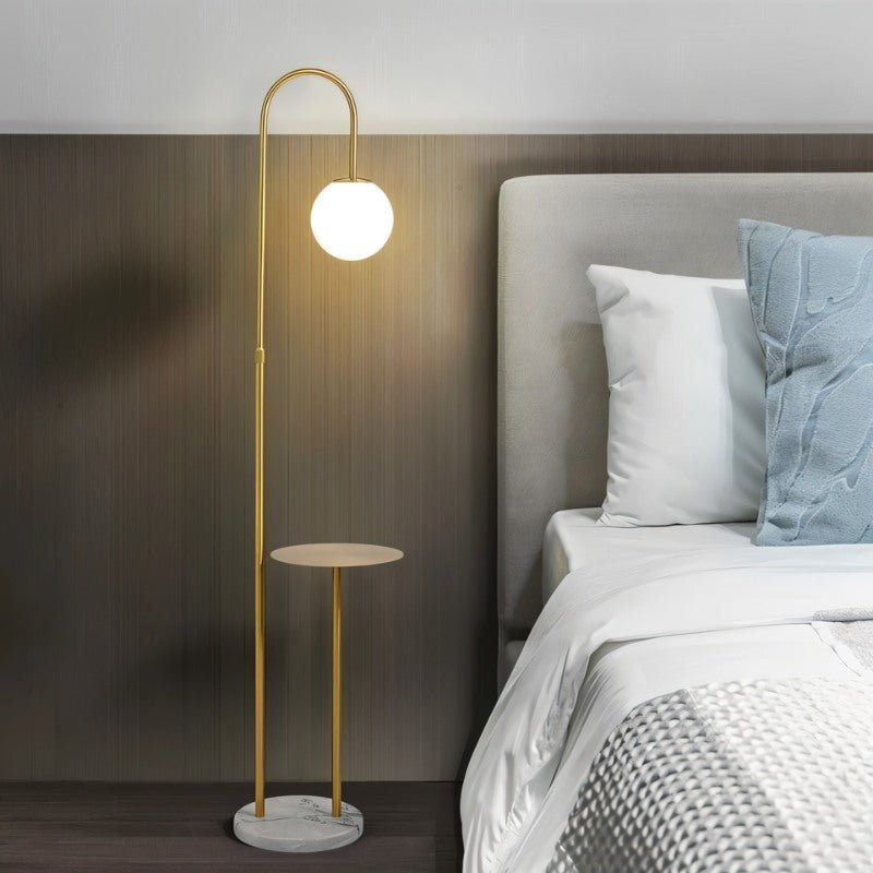The lit globe beside a bed with pillows and a padded headboard in a bedroom