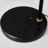 The black marble base and the brass collar where the stem enters the stone