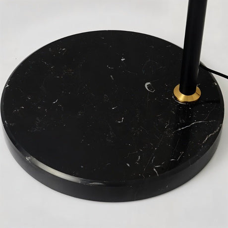 The black marble base and the brass collar where the stem enters the stone